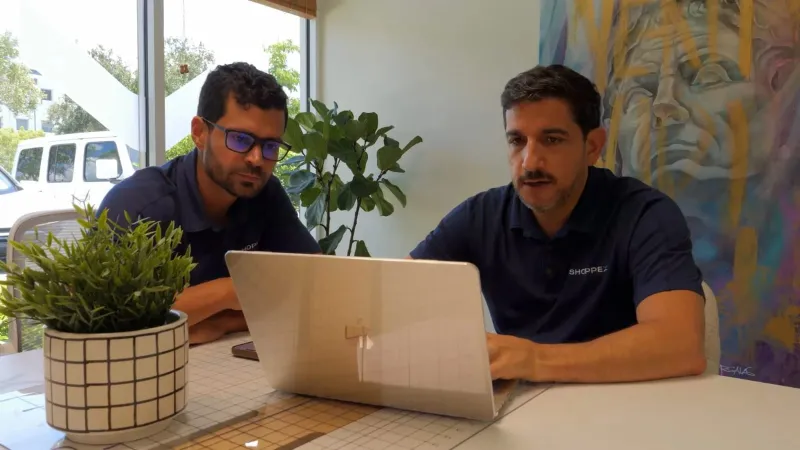 Dos integrantes del equipo de Shoppex trabajando en la oficina